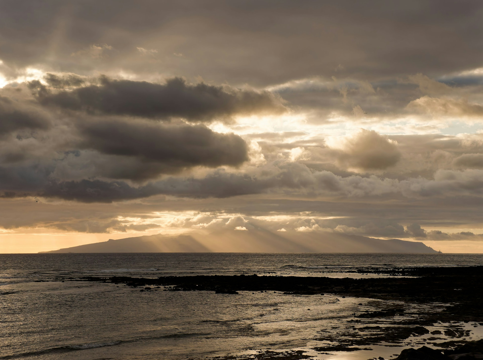 Sunlight breaking through clouds over the ocean