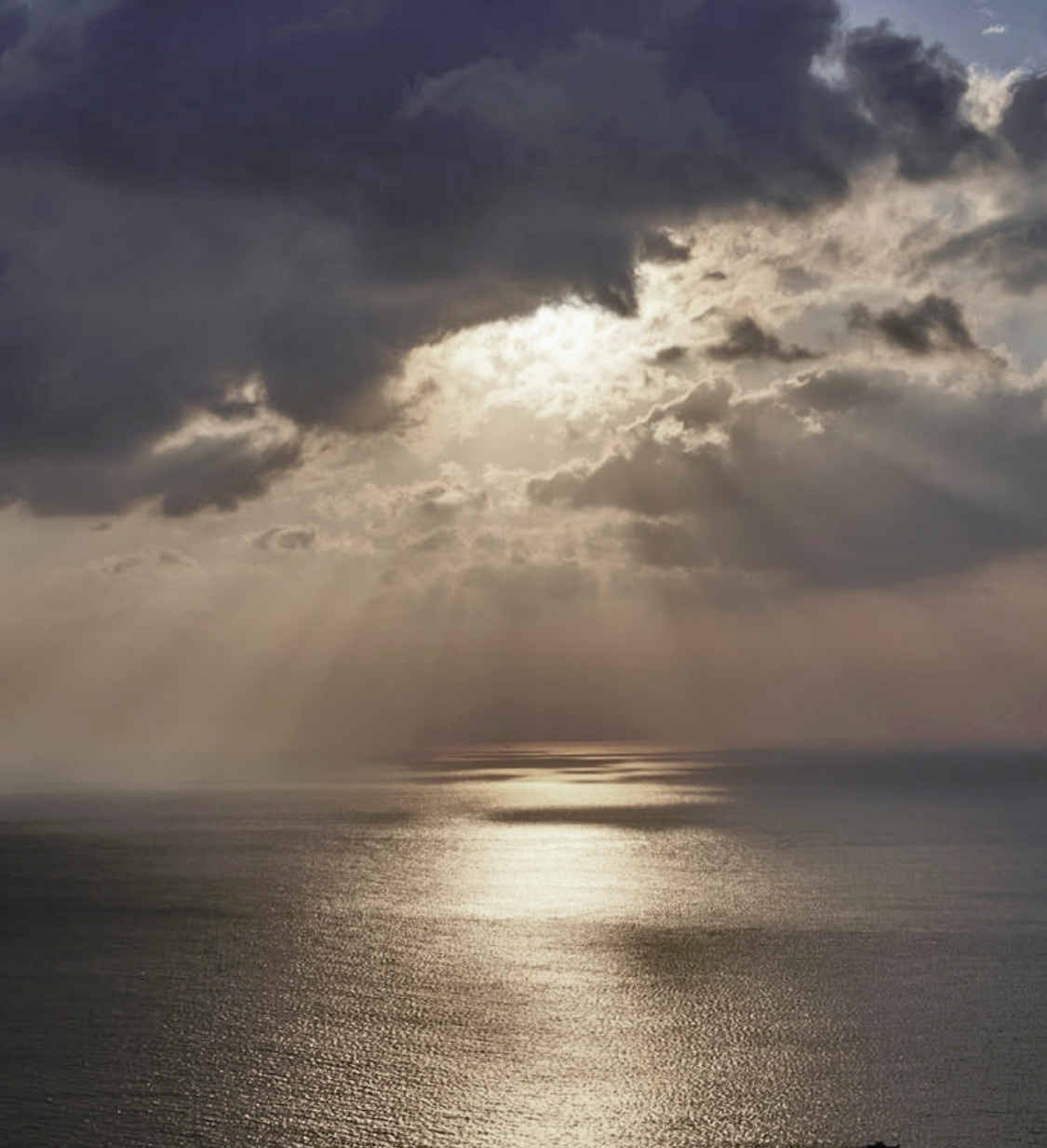 Sunbeams breaking through clouds over the sea